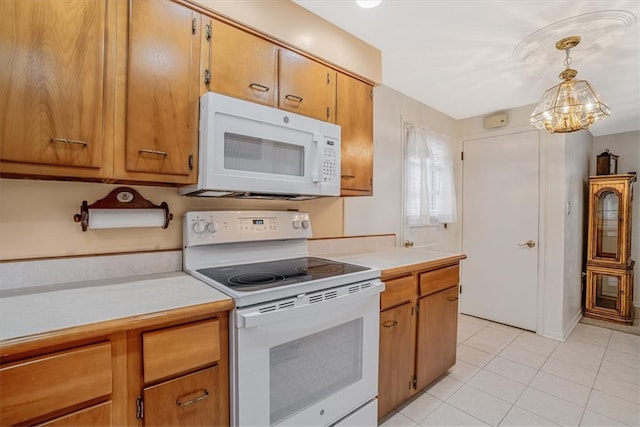 kitchen featuring white appliances, hanging light fixtures, a chandelier, and light tile patterned floors