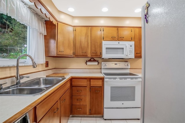 kitchen with light tile patterned floors, sink, and white appliances