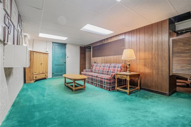 interior space featuring wooden walls, a paneled ceiling, a wall mounted air conditioner, and carpet