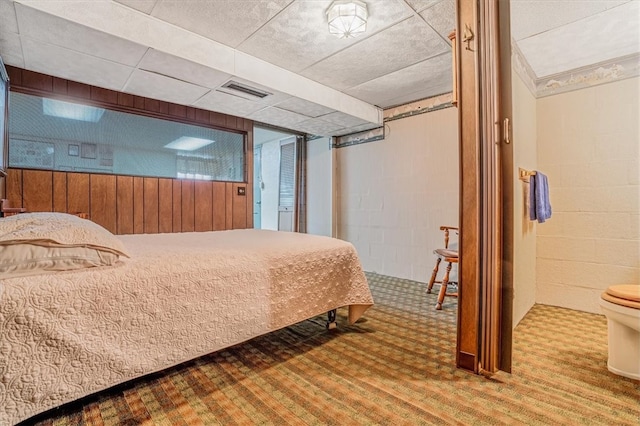 bedroom with wooden walls and hardwood / wood-style floors