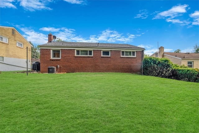 rear view of house with a yard and central air condition unit