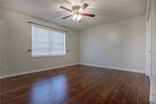 spare room with a textured ceiling, dark wood-type flooring, and ceiling fan