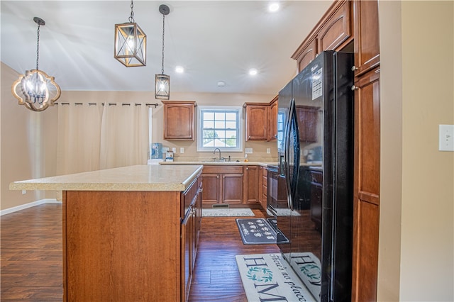 kitchen featuring sink, decorative light fixtures, dark hardwood / wood-style floors, and black fridge