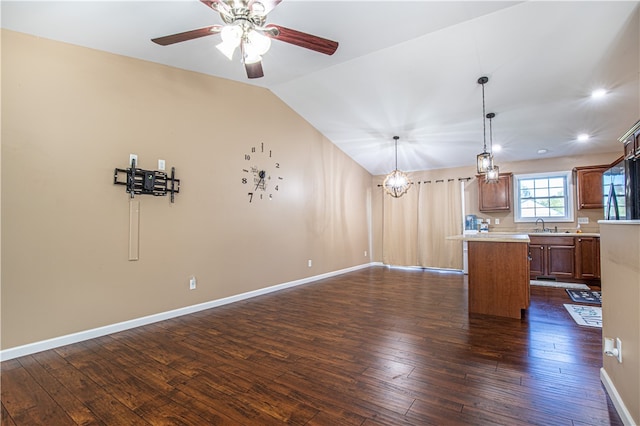 interior space with sink, a kitchen island, vaulted ceiling, pendant lighting, and dark wood-type flooring