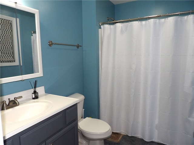 bathroom with vanity, curtained shower, and toilet