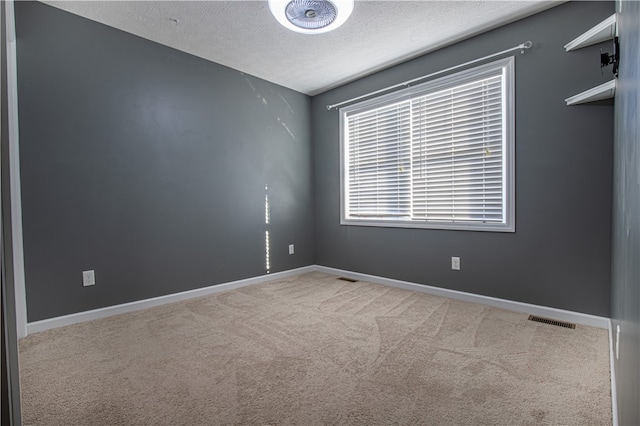 unfurnished room featuring a textured ceiling and carpet floors