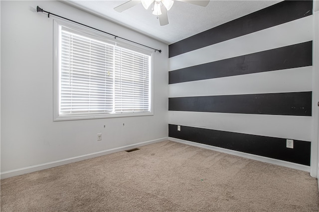 carpeted empty room with a textured ceiling and ceiling fan