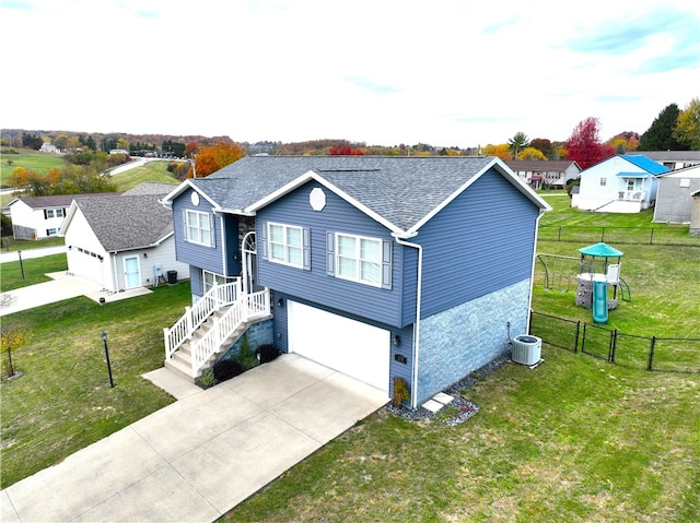 view of front of property with central air condition unit, a front yard, and a garage