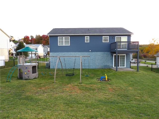 rear view of house featuring a patio, a lawn, a balcony, and central air condition unit