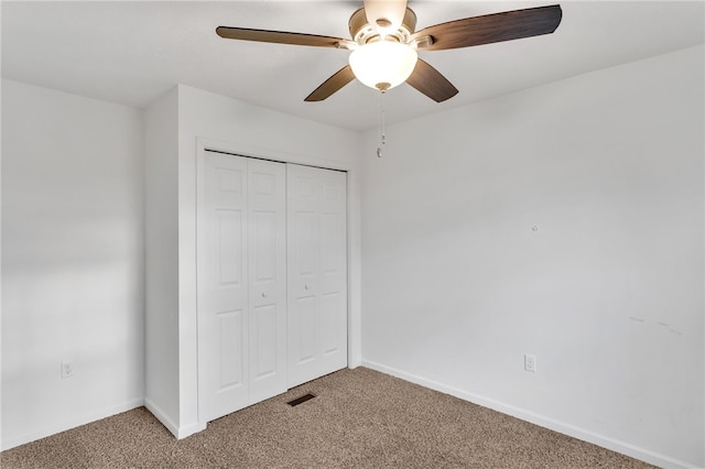 unfurnished bedroom with a closet, carpet floors, and ceiling fan