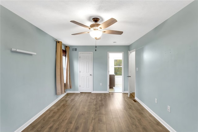 spare room with dark hardwood / wood-style floors, a textured ceiling, and ceiling fan