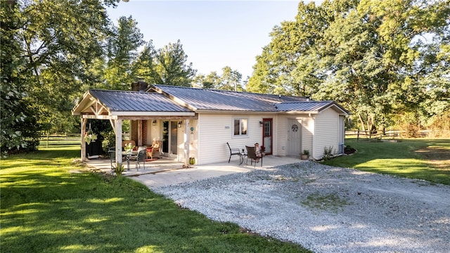 rear view of house featuring a yard and a patio