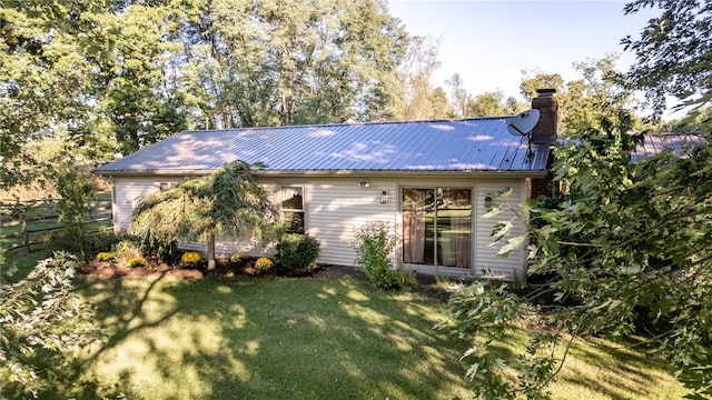 rear view of property featuring a lawn