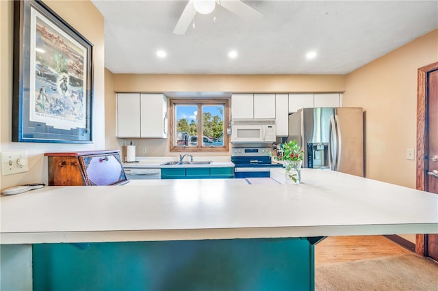 kitchen with appliances with stainless steel finishes, light wood-type flooring, a kitchen breakfast bar, and white cabinetry