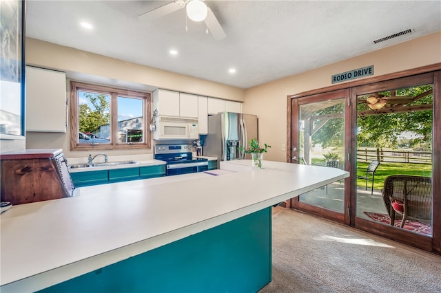 kitchen featuring ceiling fan, white cabinets, light carpet, sink, and appliances with stainless steel finishes