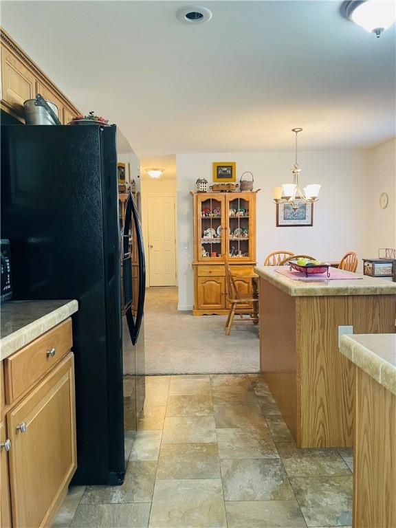 409 Ceylon Rd, Carmichaels/Cumblnd, PA 15320 - kitchen with freestanding refrigerator, light carpet, hanging light fixtures, a kitchen island, and light countertops