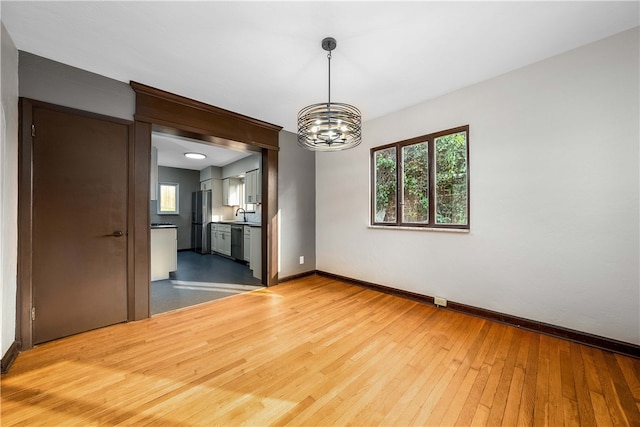 unfurnished dining area featuring hardwood / wood-style flooring and a chandelier