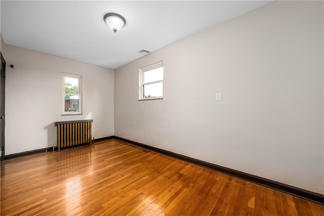 unfurnished room with light wood-type flooring and radiator