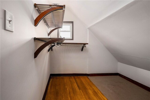 spacious closet with hardwood / wood-style flooring and vaulted ceiling