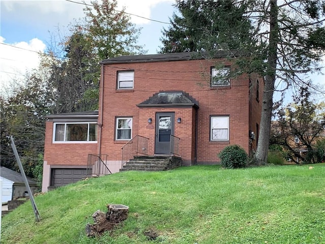 view of front of home with brick siding, a front lawn, and an attached garage