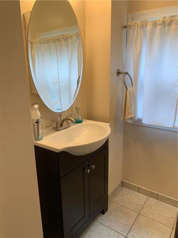 bathroom with vanity, tile patterned flooring, and baseboards