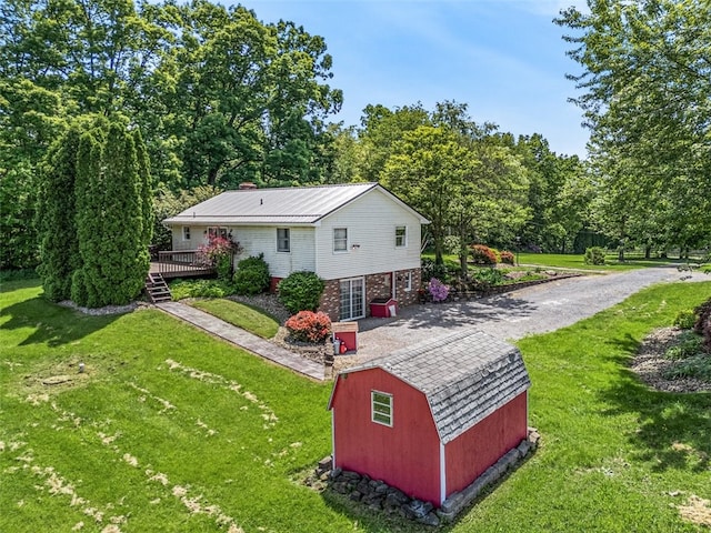 exterior space with a storage shed, a deck, and a yard