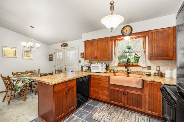 kitchen featuring pendant lighting, kitchen peninsula, black appliances, and a wealth of natural light