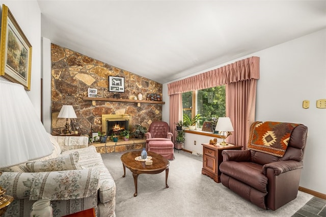 living room with carpet floors, vaulted ceiling, and a stone fireplace