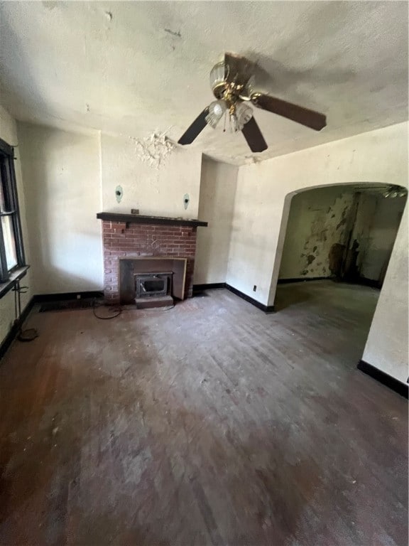 unfurnished living room featuring ceiling fan, a textured ceiling, and wood-type flooring