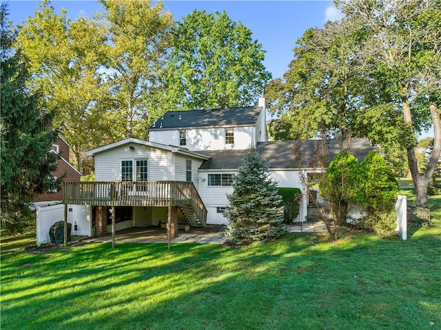 back of house with a lawn and a wooden deck