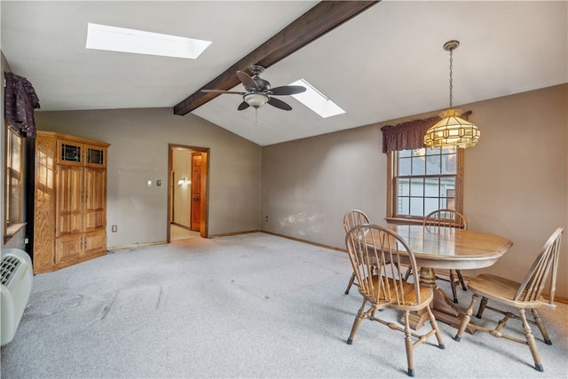 carpeted dining space featuring ceiling fan and lofted ceiling with skylight