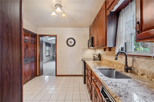 kitchen featuring sink, light stone countertops, light tile patterned floors, stainless steel range with electric stovetop, and backsplash