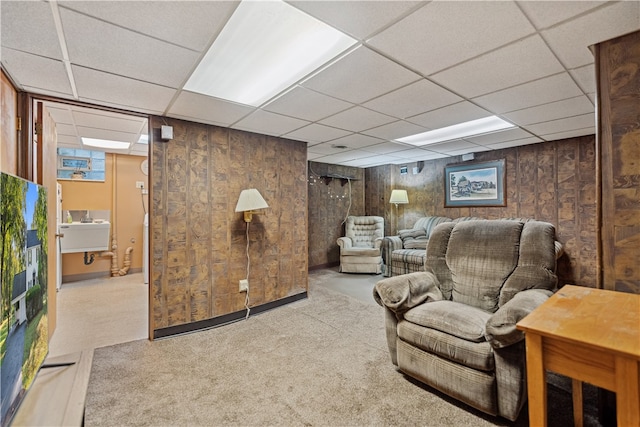 living area featuring light colored carpet, a paneled ceiling, and sink