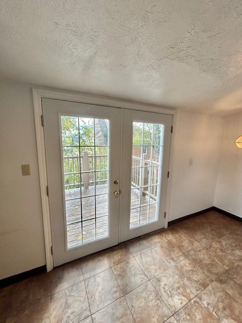 doorway to outside with french doors and a textured ceiling