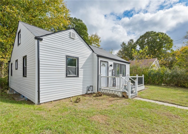 bungalow featuring a wooden deck and a front lawn