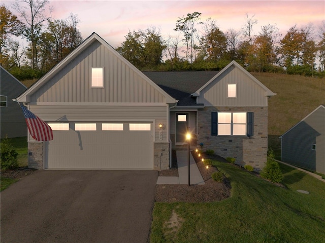 view of front of house with aphalt driveway, a garage, stone siding, a front lawn, and board and batten siding