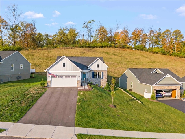 view of front of home featuring aphalt driveway, board and batten siding, and a front yard