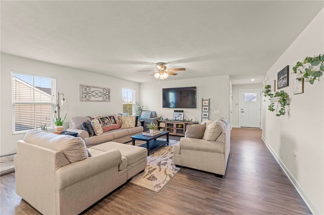 living room with dark wood-type flooring, plenty of natural light, and ceiling fan