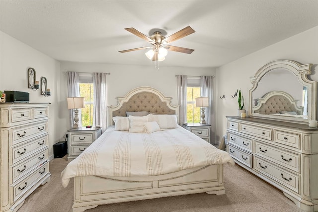 carpeted bedroom featuring ceiling fan and multiple windows