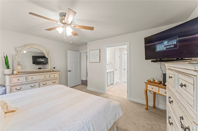 carpeted bedroom with ensuite bath and ceiling fan