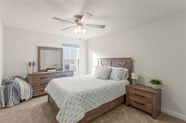 bedroom featuring light colored carpet, ceiling fan, and baseboards