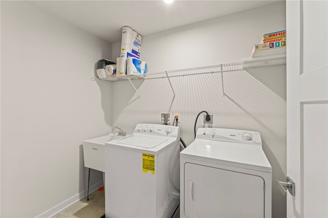 laundry room featuring washer and dryer, laundry area, a sink, and baseboards