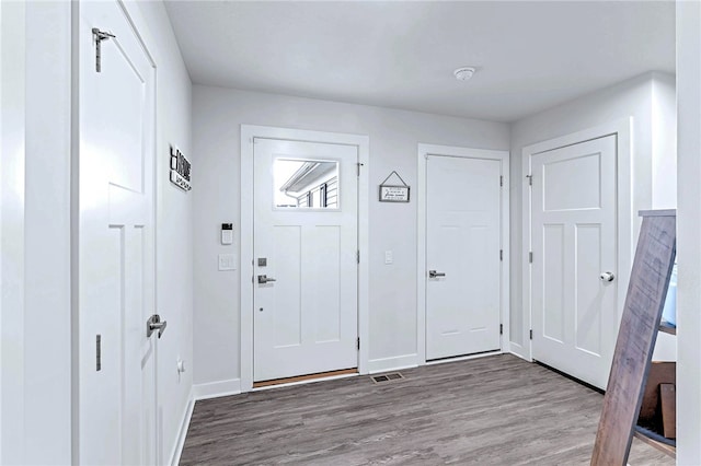 entryway with visible vents, baseboards, and wood finished floors