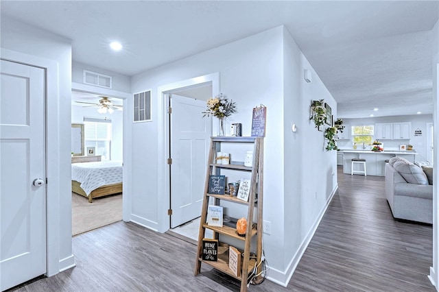 hallway with baseboards, dark wood-type flooring, visible vents, and recessed lighting