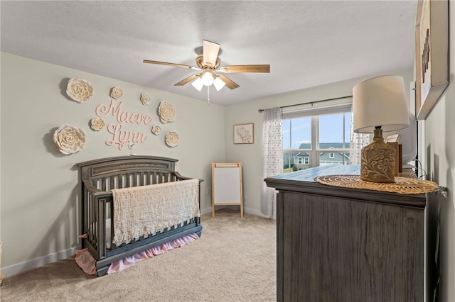 bedroom with light carpet, a textured ceiling, and baseboards