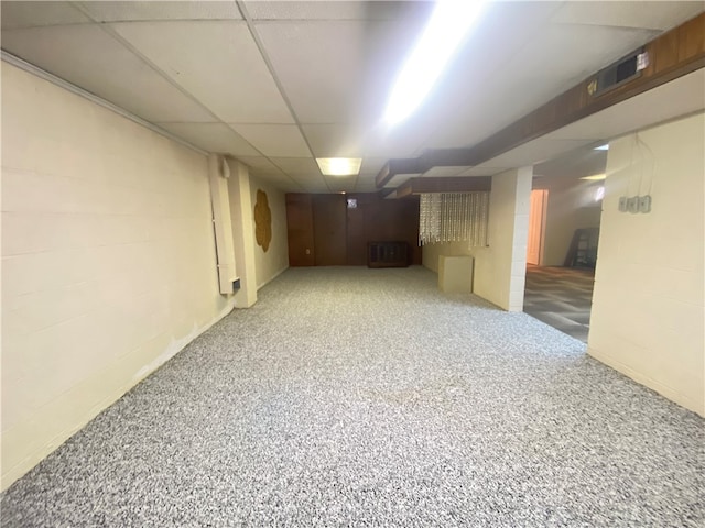 basement featuring a drop ceiling and carpet flooring