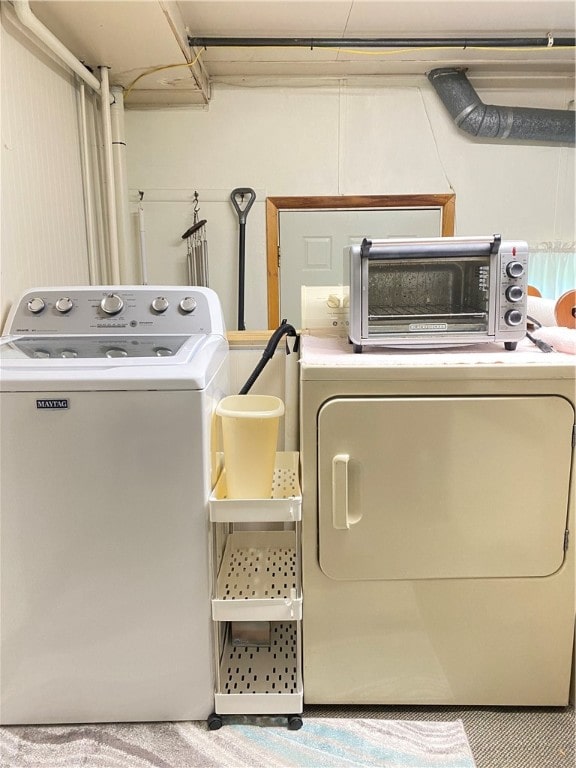 laundry room featuring light carpet and washing machine and dryer