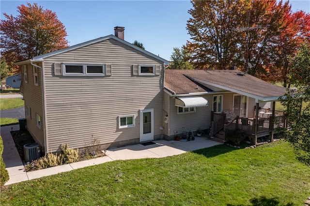 rear view of property with a wooden deck and a lawn