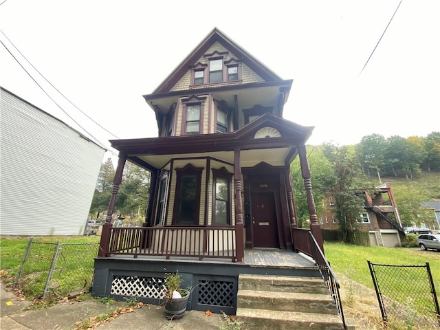 victorian-style house with a front lawn and covered porch