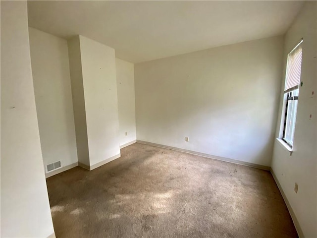spare room with plenty of natural light, carpet floors, and baseboards